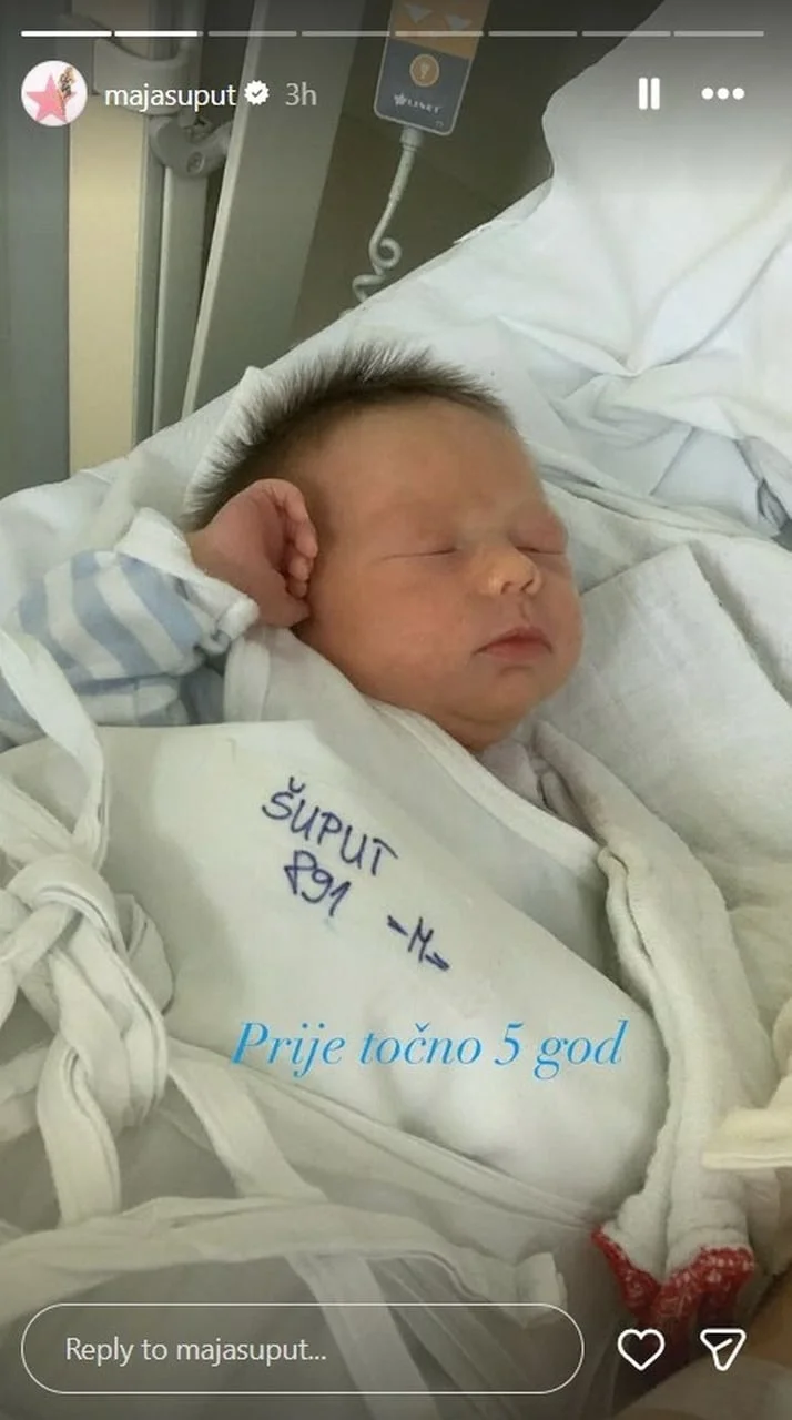 Novorođenče u rodilištu umotano u bijelu tkaninu s prezimenom Šuput.