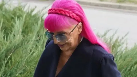 Zorica Brunclik s prepoznatljivom ružičastom kosom i sunčanim naočalama.