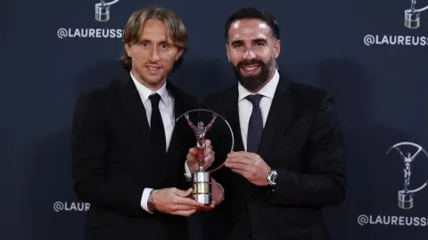 Luka Modrić i Dani Carvajal u odijelima drže sportski trofej na svečanoj dodjeli.