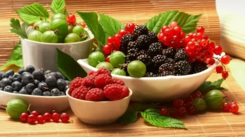 Razno bobičasto voće poput malina, kupina i borovnica posluženo u bijelim zdjelicama.