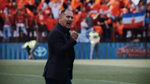 Trener Igor Štimac u tamnom saku pokazuje šaku na rubu nogometnog terena