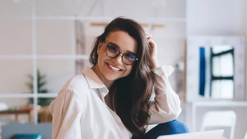 Nasmijana žena s naočalama u svijetloj prostoriji