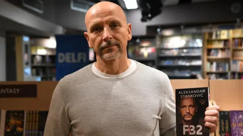Novinar Aleksandar Stanković u knjižari drži svoju knjigu