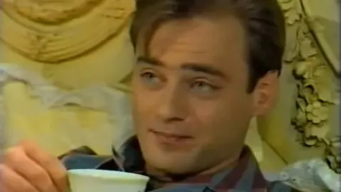 Mladen Barbarić kao Pegula u sceni iz serije Velo misto s šalicom u ruci.