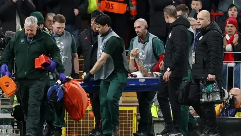 Medicinsko osoblje iznosi ozlijeđenog nogometaša na nosilima s terena stadiona Anfield.