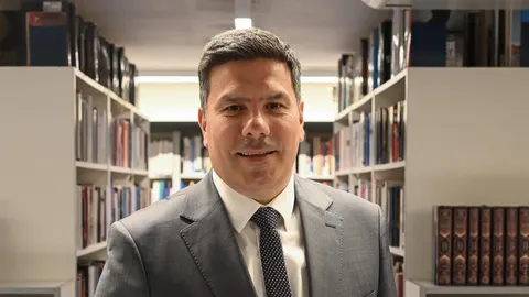 Portret Tomislava Lendića u odelju ispred polica s knjigama