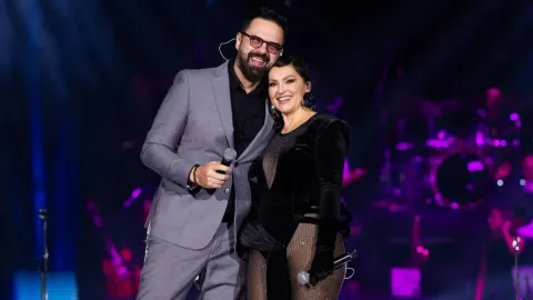 Nina Badrić i Petar Grašo zagrljeni na pozornici s mikrofonima u rukama.