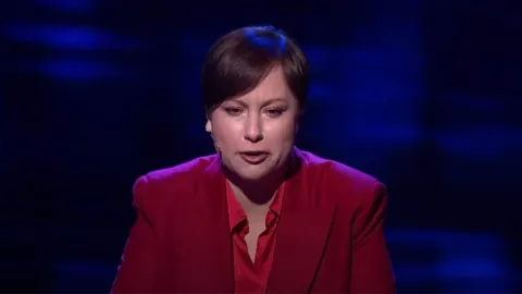 Morana Zibar u crvenom saku pred plavom pozadinom studija