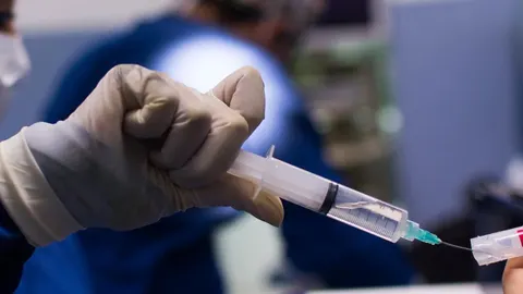 Ruka kirurga u sterilnoj rukavici drži špricu u operacijskoj sali