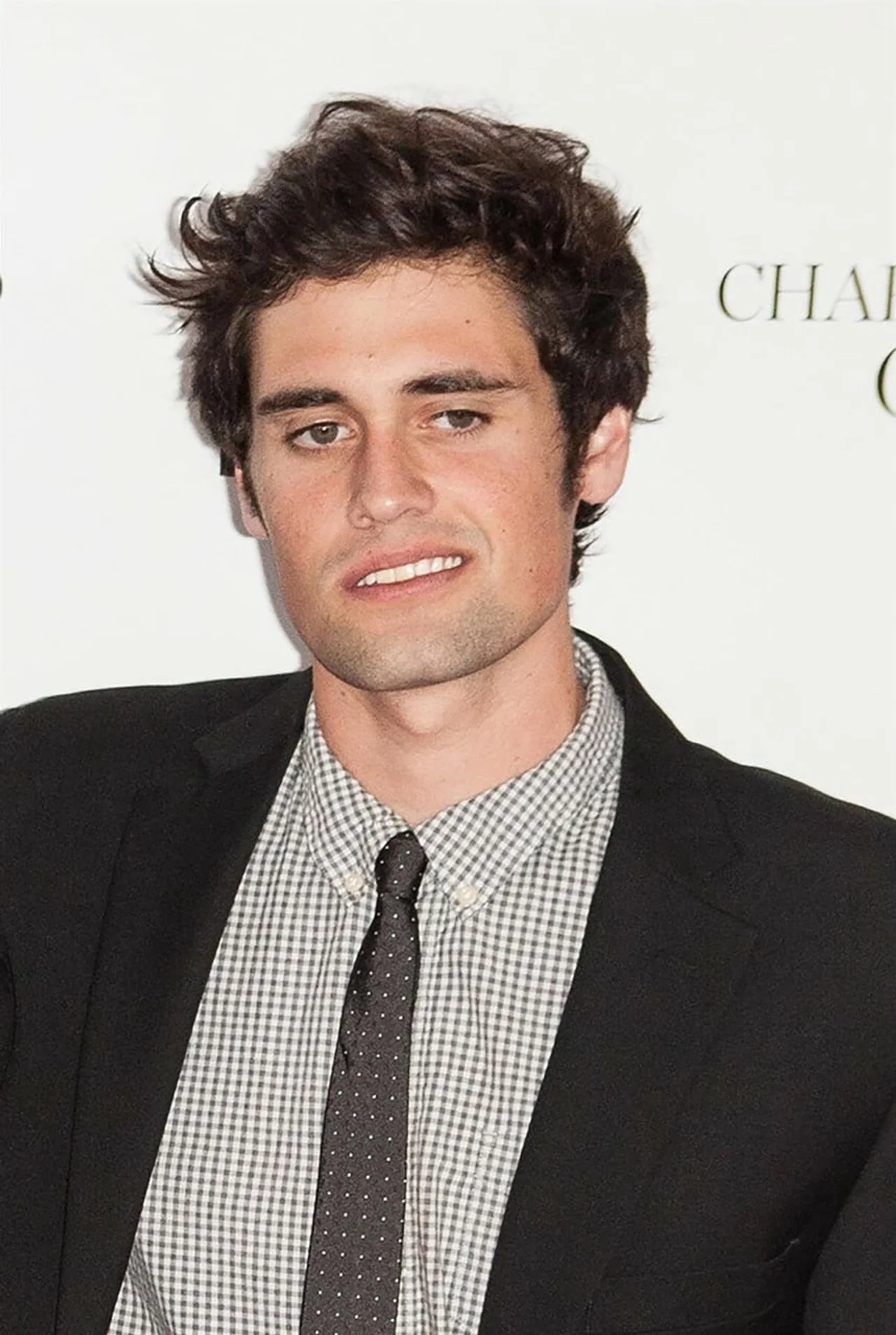 Portret Nicka Reinera u tamnom saku i košulji s točkastom kravatom.