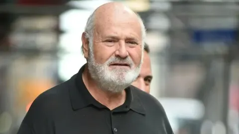 Redatelj Rob Reiner u crnoj majici s bijelom bradom gleda prema kameri.