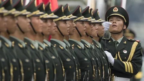 Redak cijelih kineskih vojnika u tamnozelenim uniformama i šapkama