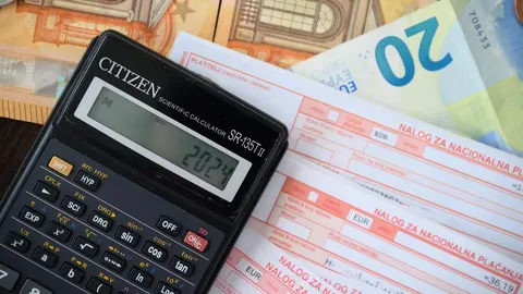 Kalkulator, novčanice od 20 eura i računi za plaćanje na stolu