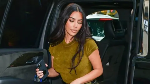 Kim Kardashian izlazi iz crnog automobila u maslinastoj majici