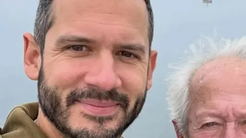 Boris Rogoznica nasmiješen u krupnom planu uz svog oca na otvorenom