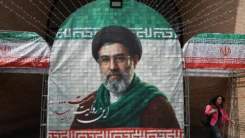 Veliki portret Mojtabe Khameneija s turbanom i naočalama na zidu u Teheranu