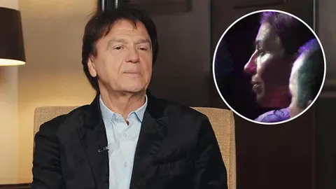 Zdravko Čolić u crnom saku i plavoj košulji s umetkom drugog portreta