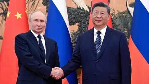 Vladimir Putin i Xi Jinping rukuju ispred zastava Rusije i Kine