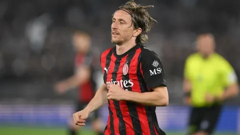 Luka Modrić u crveno-crnom dresu AC Milana trči nogometnim terenom
