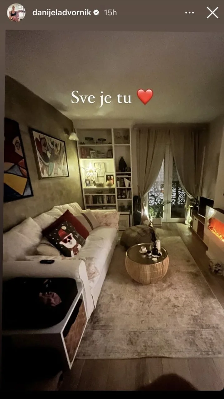 Uređen dnevni boravak s bijelim kaučem, tepihom i policama za knjige
