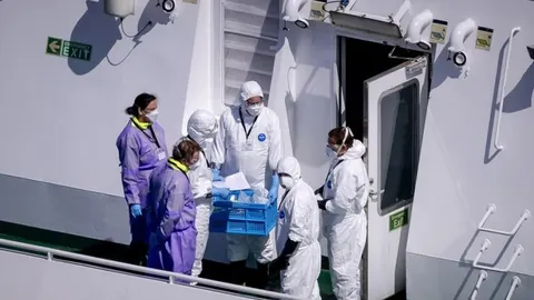Medicinski tim u zaštitnim odjevima na palubi kruzera