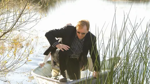 David Caruso u crnom odelu i sunčanim naočalama u malom čamcu