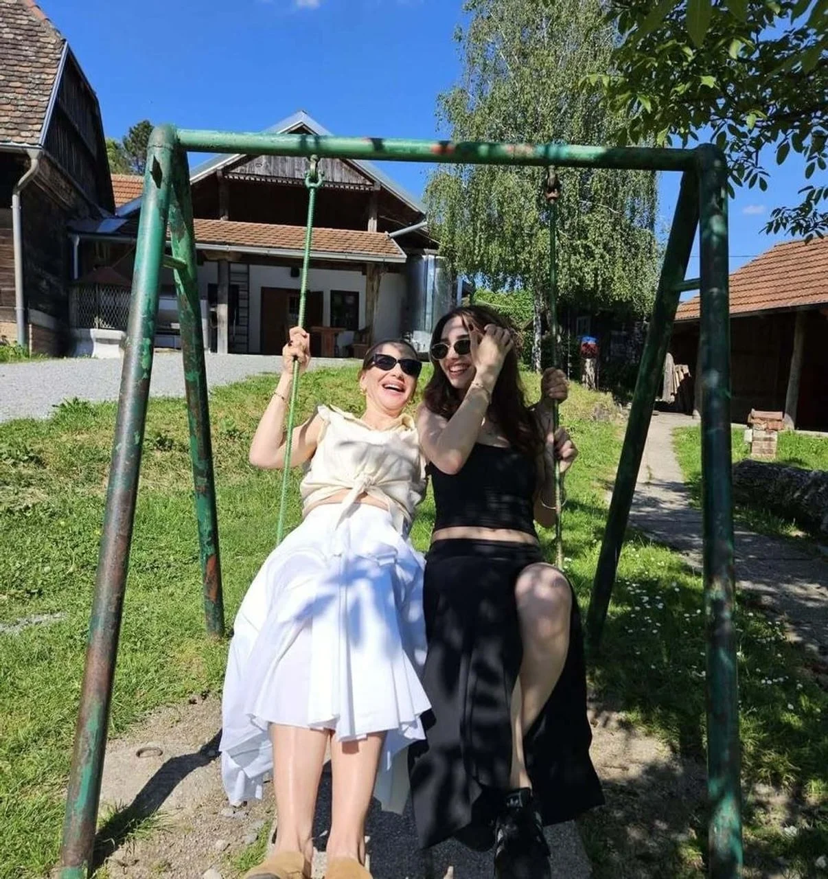 Ecija i Cvita Ojdanić sjede na zelenim metalnim ljuljačkama