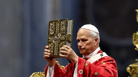 Papa u crvenoj odjeći drži raskošno ukrašeno zlatno evanđelje