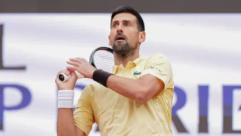 Novak Đoković u žutoj položnici drži tenisku reket