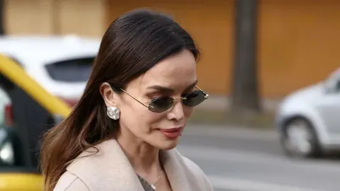 Profil pjevačice Severine s tamnim sunčanim naočalima i bež kaputom