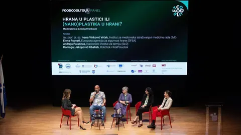 Grupa stručnjaka sjedi na pozornici pred ekranom o plastici u hrani