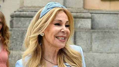 Portret nasmijane Ane Obregón u plavom izgledu s trakom u kosi