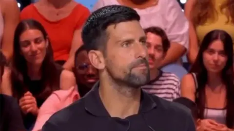 Portret Novaka Đokovića s ozbiljnim izrazom lica u publici