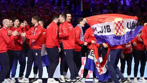 Hrvatski rukometni reprezentovci u crvenim dresovima slave s zastavom