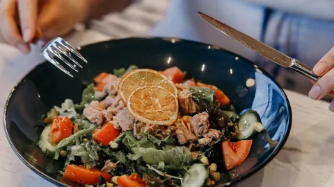 Zdrava salata s tunjevinom, rajčicom i krumpirom u crnoj zdjeli