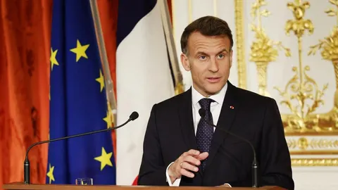 Emmanuel Macron u tamnom odelu ispred zastava Francuske i Europske unije