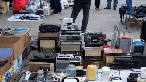 Različiti stari radio-aparati i gramofoni izloženi na otvorenom buvljaku
