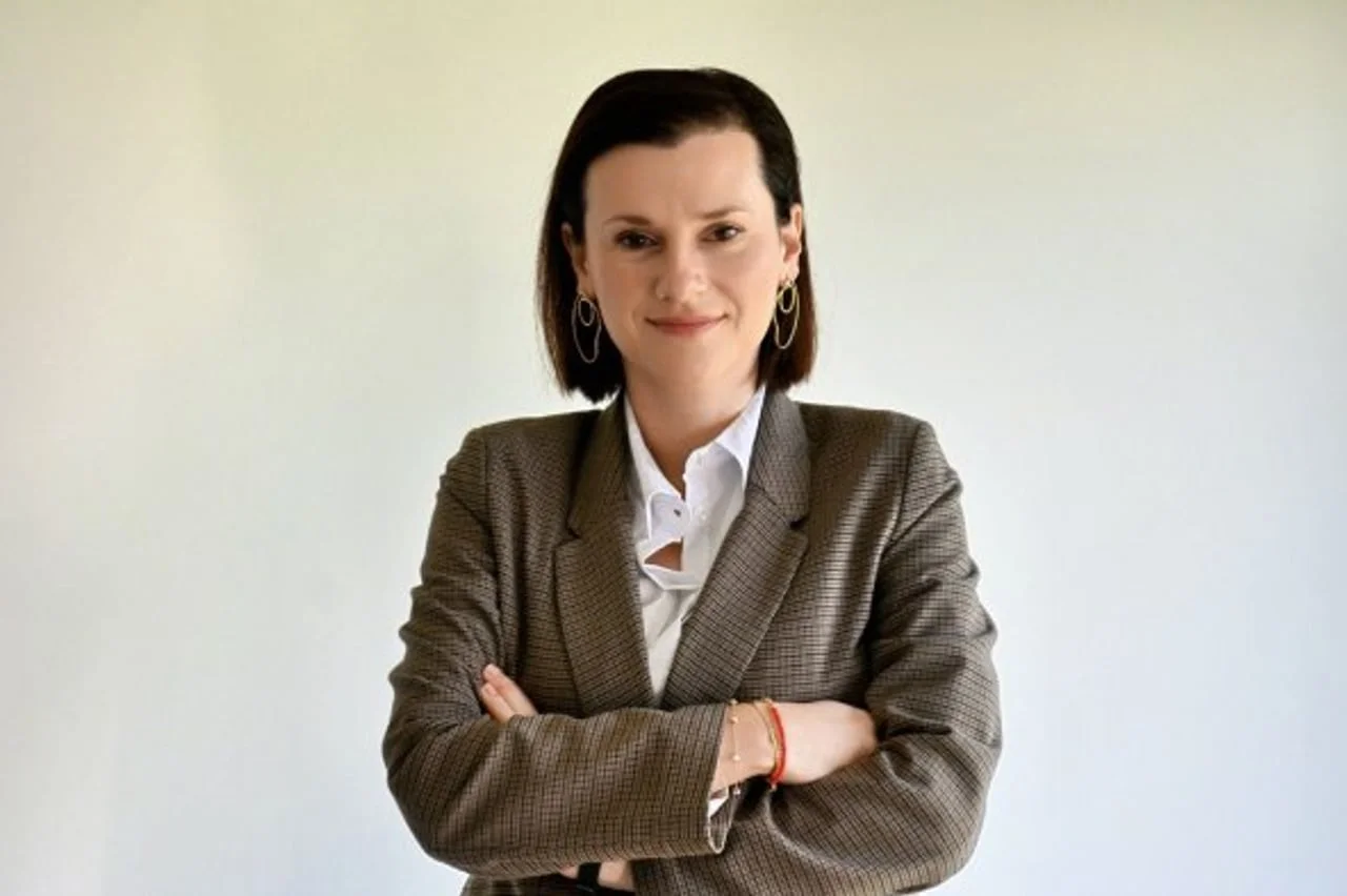 Portret žene s kratkom tamnom kosom u sivo-smeđem saku