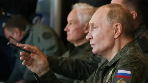 Vladimir Putin u vojnoj uniformi drži mobilni telefon