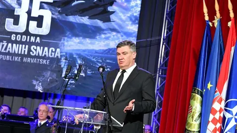 Predsjednik Zoran Milanović govori za govornicom ispred zastava i ekrana