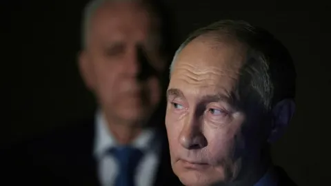 Blizu krupni plan Vladimira Putina s ozbiljnim izrazom lica
