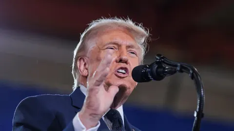 Donald Trump govori u mikrofon, gestikulirajući rukom
