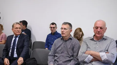 Grupa muškaraca sjedi u prostoriji, u sredini je Božidar Kalmeta