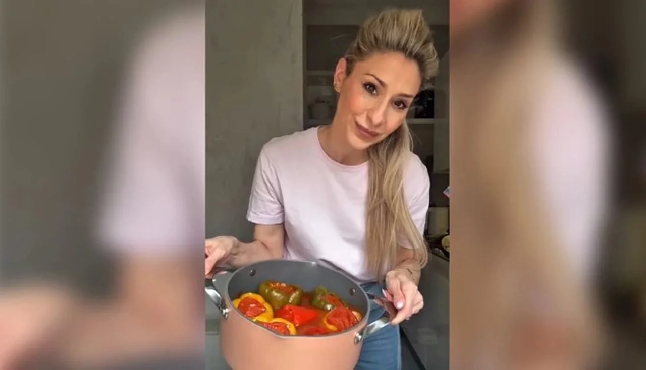 Žena drži veliki lonac s punjenim paprikama u raznim bojama