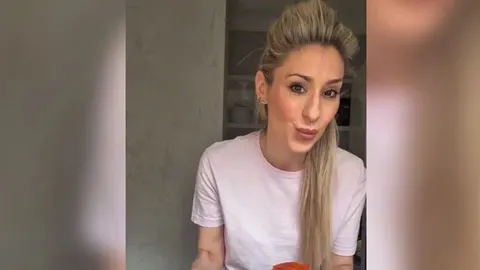 Plavokosa žena u svijetloj majici u kuhinji