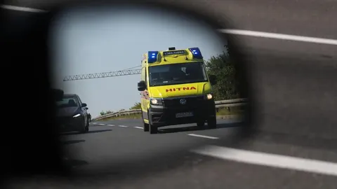 Žuto vozilo hitne pomoći s upaljenim plavim svjetlima na cesti