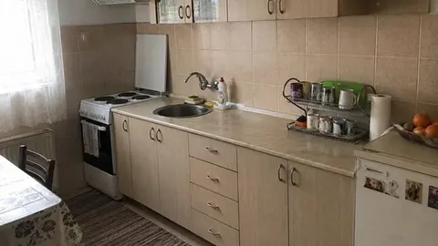 Kuhinja s bežnim elementima i svijetlim pločicama na zidu