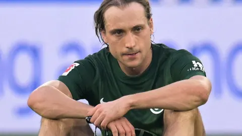 Nogometaš Lovre Majer u zelenom dresu Wolfsburga s ozbiljnim izrazom lica
