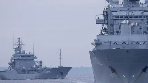 Dva siva vojni broda na moru pod sivim nebom