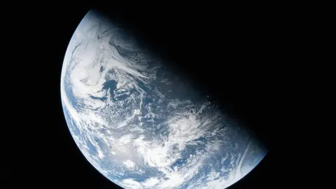 Pogled na planet Zemlje iz svemirskog prostora s vidljivim oblacima i oceanima